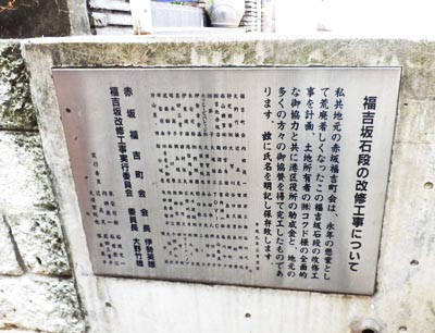 坂上の壁面にある「福吉坂石段の改修工事について」案内板